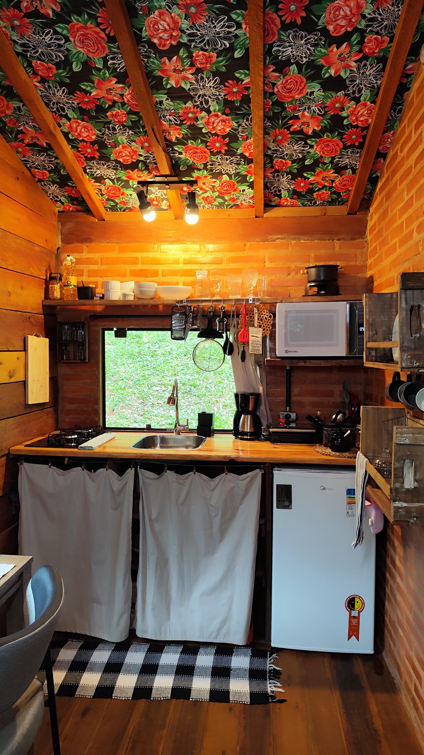 Bancada da cozinha da cabana organizada com itens essenciais de culinária, unindo funcionalidade e decoração rústica.