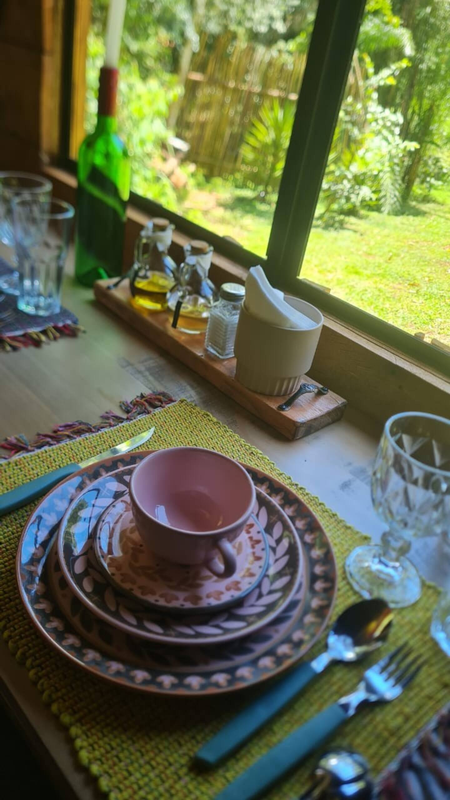Detalhe de louça marrom e rosa escolhidas para a cabana Tetsu do Cabanário, com cerâmicas artesanais e peças lúdicas que compõem a decoração da mesa.