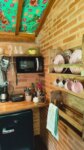 Cozinha equipada na cabana com cafeteira, microondas, forninho, louças,