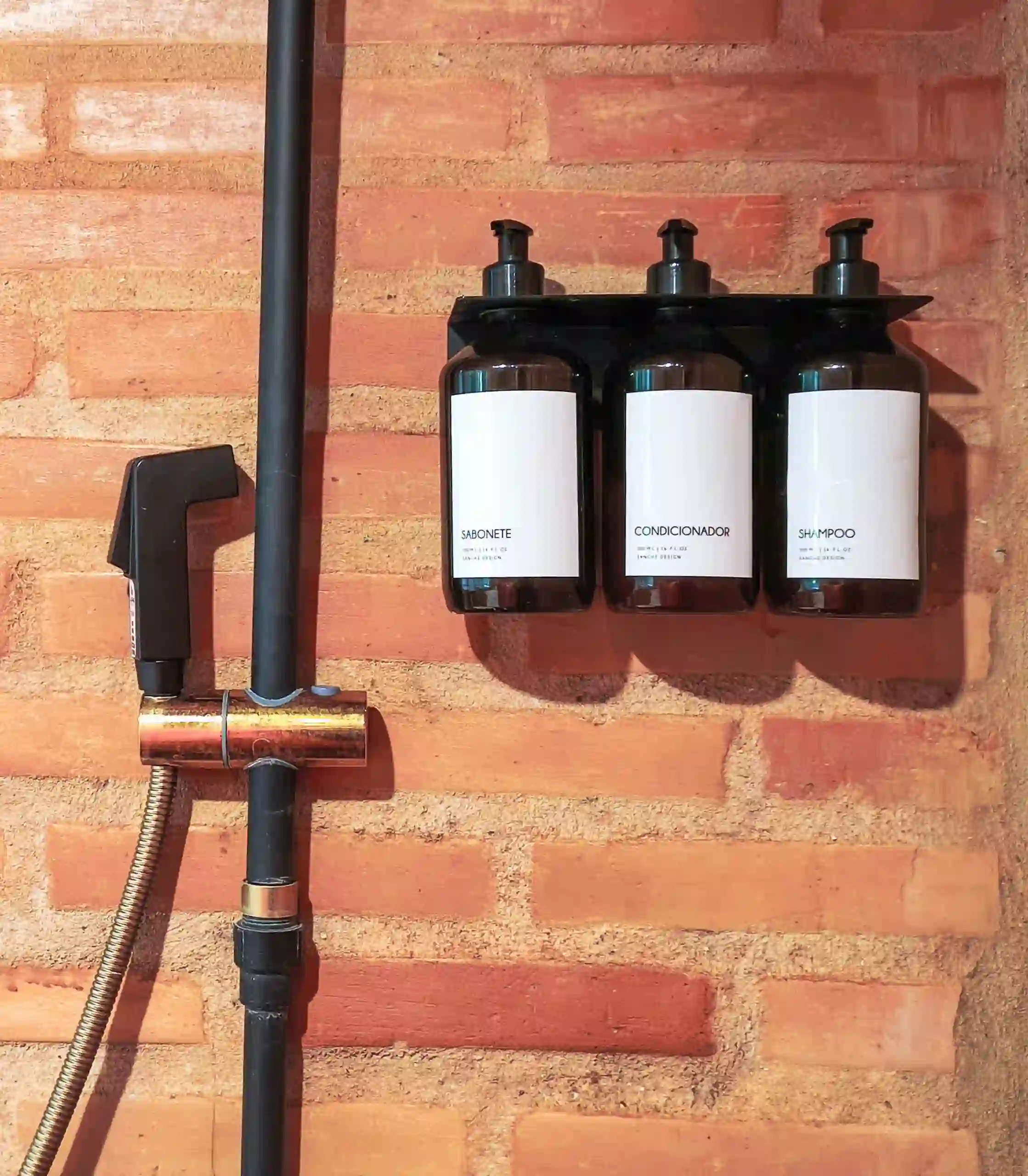 Amenidades de banho em frascos reutilizáveis fixos, garantindo conforto ao hóspede sem gerar lixo desnecessário.