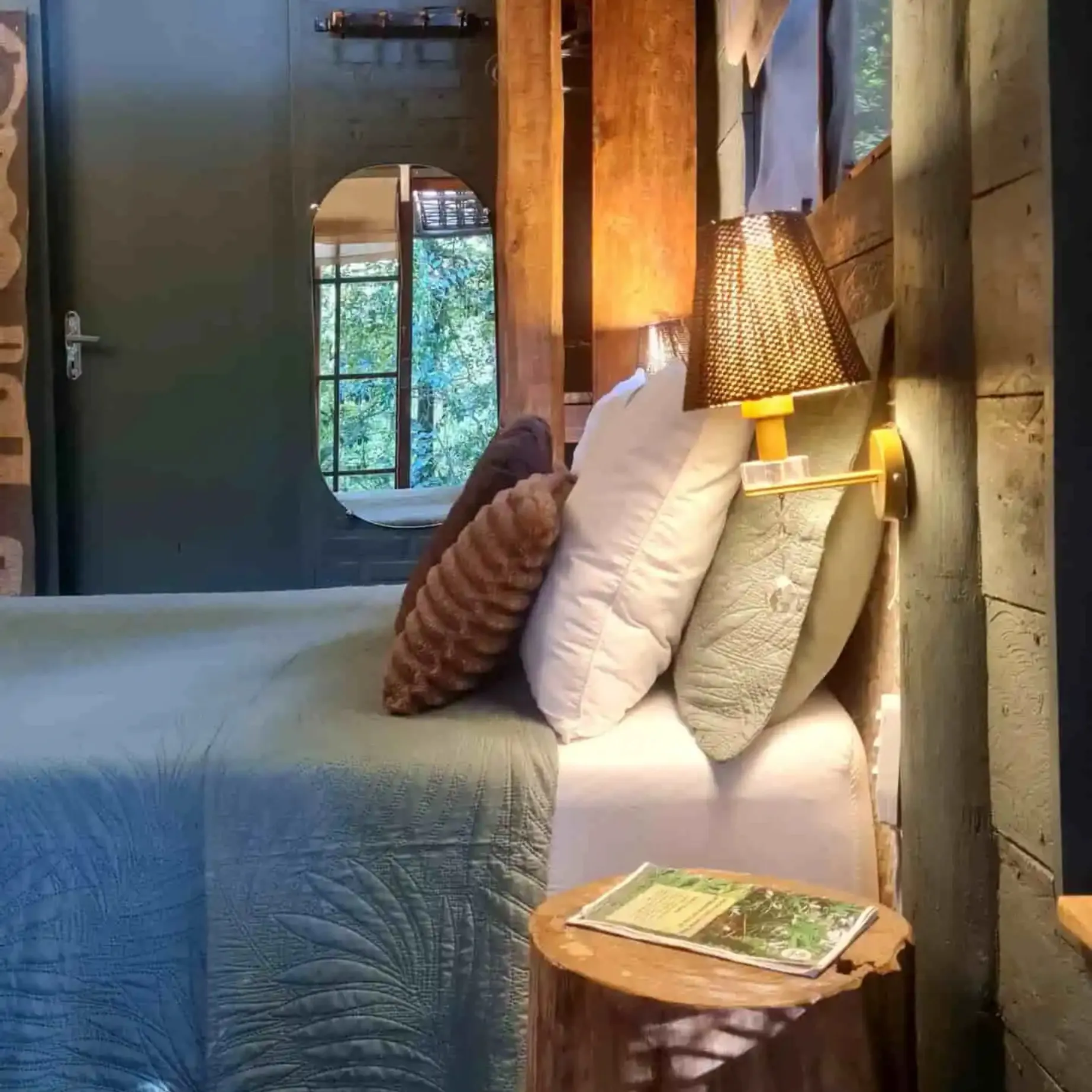travesseiros aconchegantes na cama em quarto decorado na cor verde de cabana na mata
