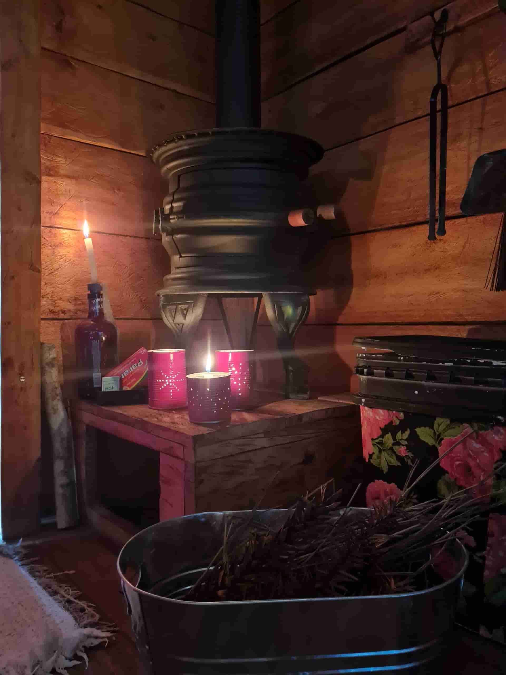 Decoração lúdica de porta velas feitas de lata vermelha e lareira rústica.