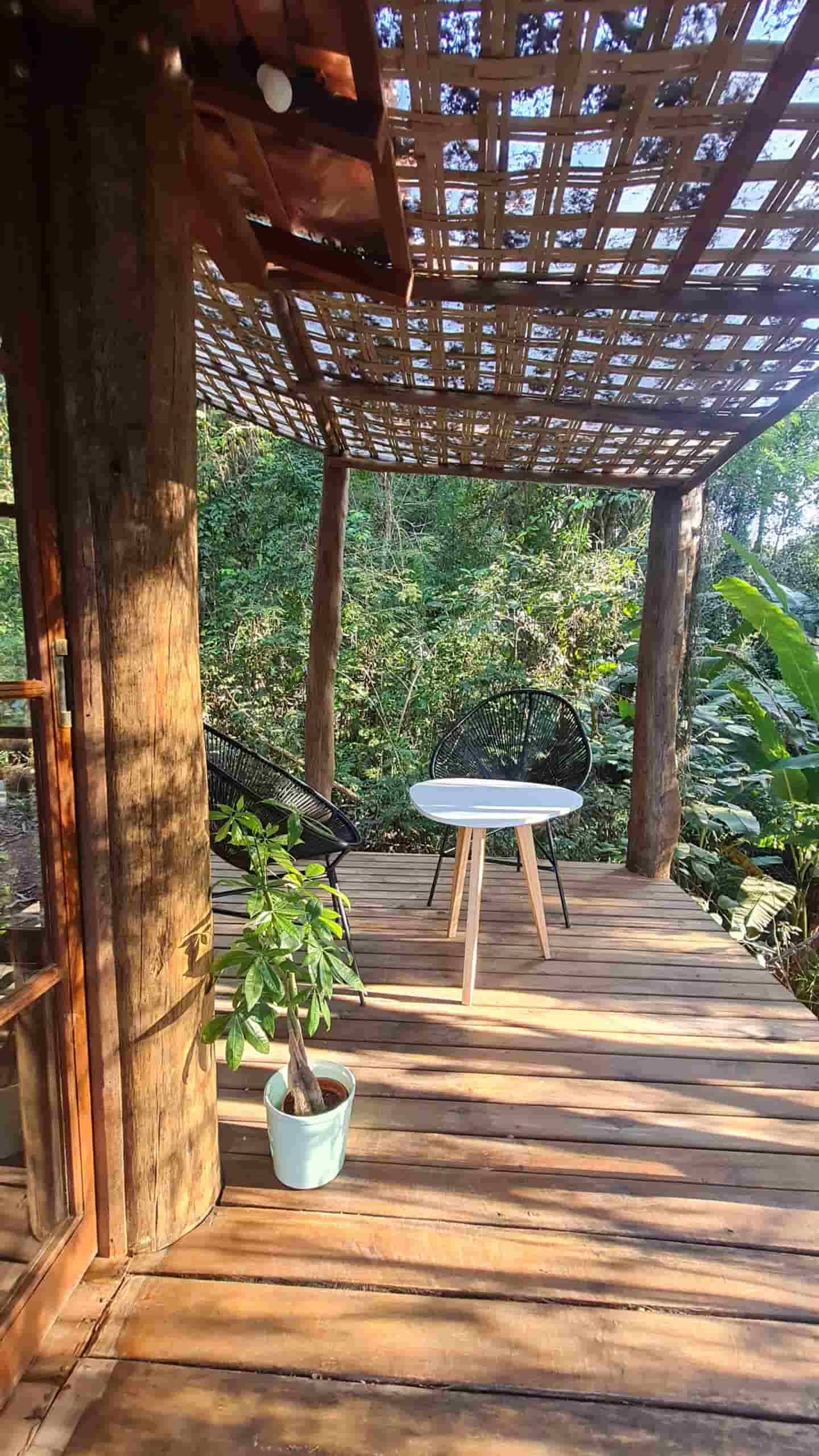 Deck de madeira privativo com cadeiras de descanso e vista para a mata, perfeito para contemplação e café da manhã ao ar livre.