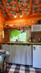 Cozinha da cabana com teto em tecido de chita. Decoração rustica e artesanal com cortinas de algodão em cabana de madeira