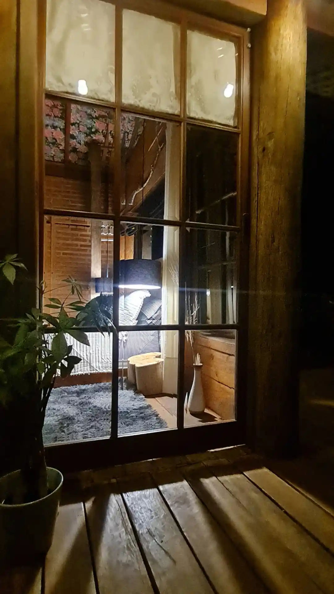 Noite em quarto de cabana de madeira e iluminação de luminaria preta pendente e aconchegante