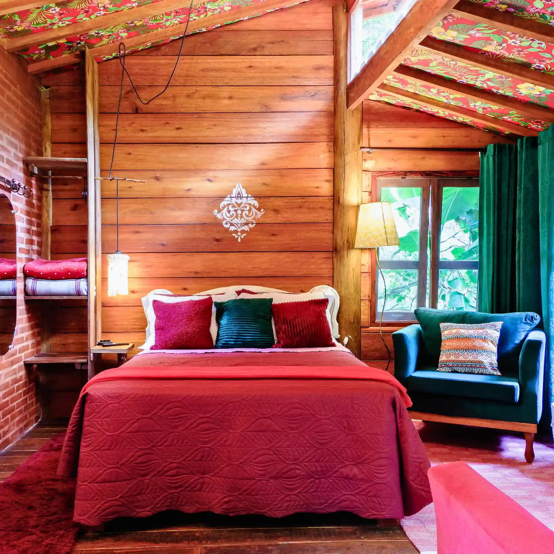 Quarto de cabana de madeira com decoração vermelha e verde.