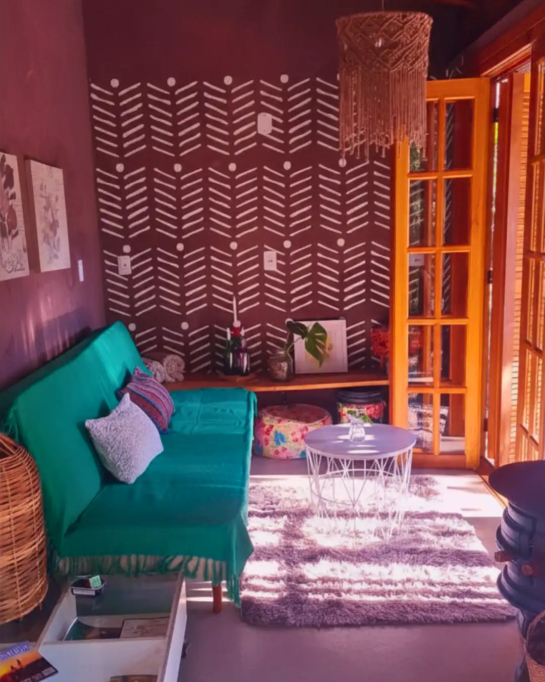 Sala da casa de campo iluminada pelo sol. Decoração em verde e marrom com detalhes tribal