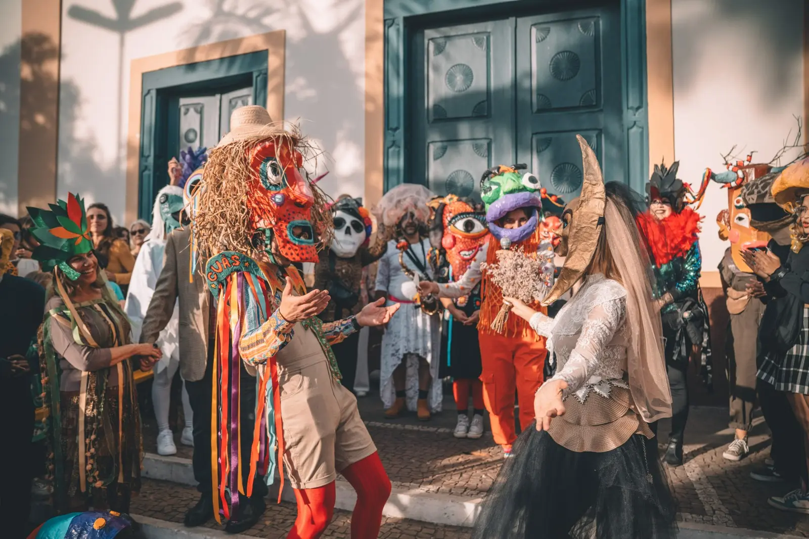 Artistas com máscaras artesanais e fantasias coloridas no Arraial Surreal de Cunha